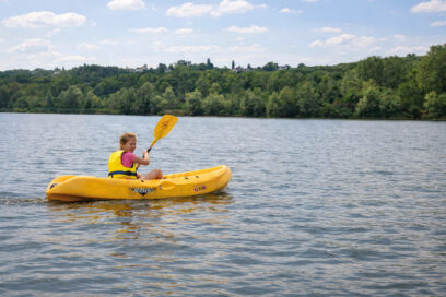 Petite fille dans un kayak jaune sur l'étang de la base de Jabines. - Agrandir l'image, fenêtre modale
