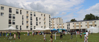 Groupe d'enfants et d'adolescents qui jouent sur un terrain de football à plusieurs jeux sur la place du Couchant à Lizy-sur-Ourcq.