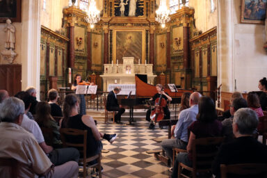 3 musiciens du Caravensérail jouent du clavcin et du violoncelle dans l'église lors d'un spectacle