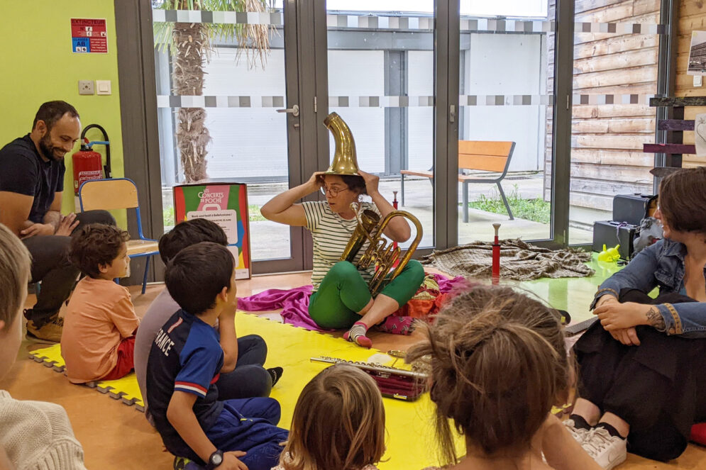 Groupe de parents et enfants face aux artistes des Concerts de Poche lors d'un atelier.
