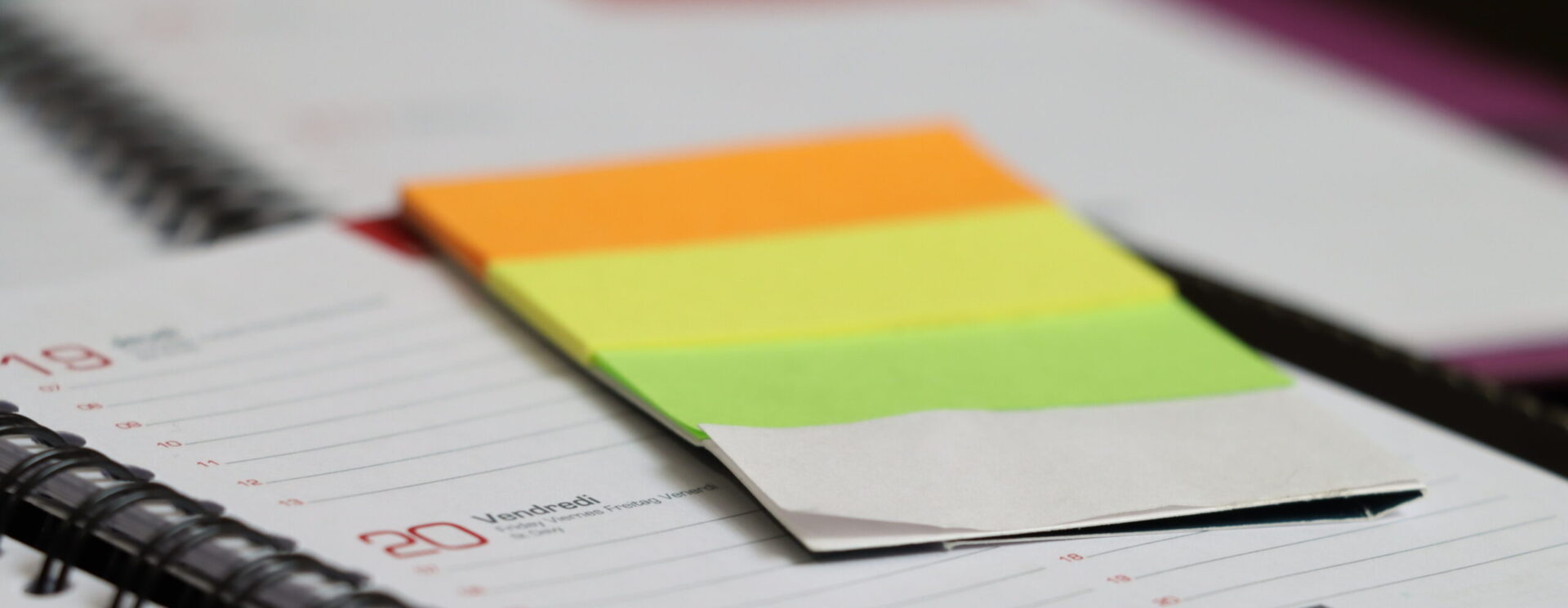 Zoom d'un agenda et de post-it colorés