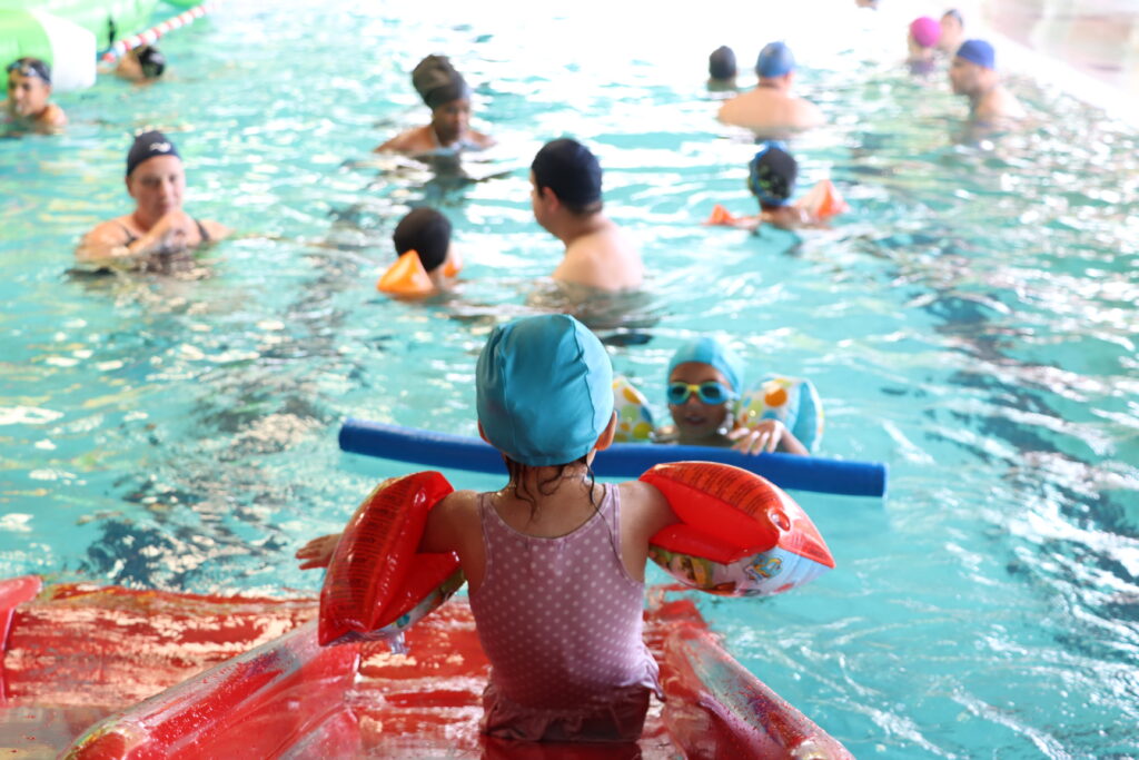 De nombreuses familles autour des jeux ludiques aquatiques dans la piscine  - Agrandir l'image, fenêtre modale