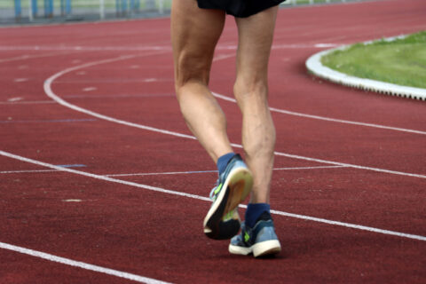 Zoom sur les jambes d'un coureur sur le stade d'athlétisme Micheline Ostermeyer à Ocquerre
