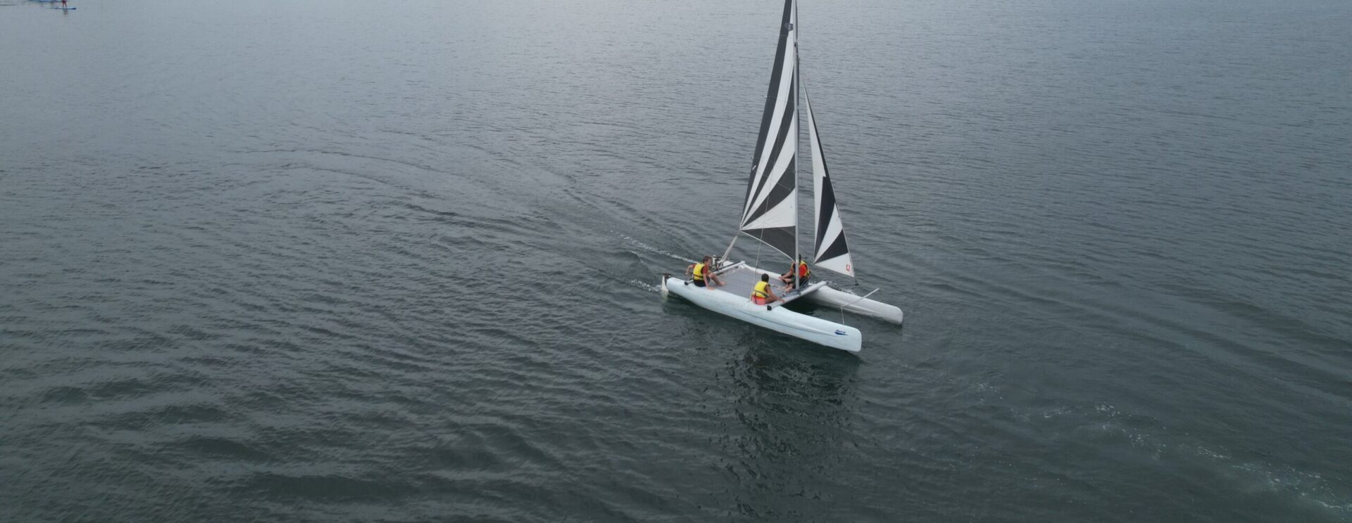 Vue aérienne d'un groupe d'enfants sur un catamaran lors des Vac'enSports à la base de loisirs de Jablines