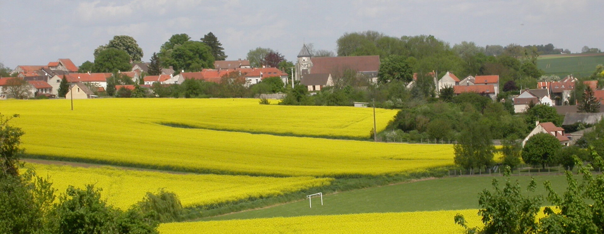 Paysage de champs vallonné et village de Puisieux