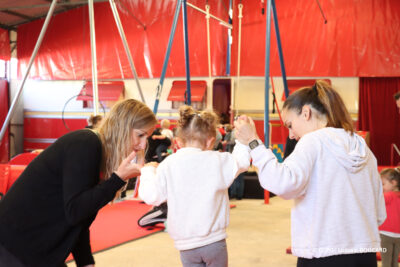 Deux accompagnatrices aidant une petite fille à rester en équilibre sur un fil à l'école Joseph BOUGLIONE à Lizy-sur-Ourcq - Agrandir l'image 27 sur 30, fenêtre modale