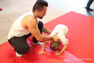 Artiste aidant une enfant à réaliser une roulade à l'école Joseph BOUGLIONE à Lizy-sur-Ourcq - Agrandir l'image 26 sur 30, fenêtre modale