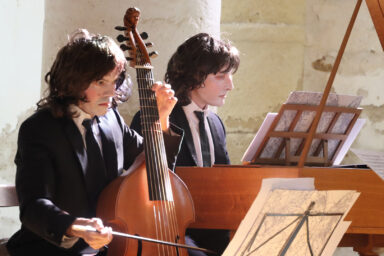 2 musiciens du Caravensérail jouent du clavcin et du violoncelle dans l'église lors d'un spectacle
