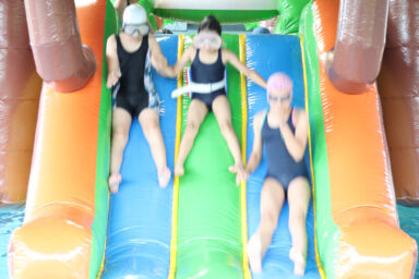 3 enfants descendent d'une structure gonflable à la piscine du Pays de l'Ourcq.