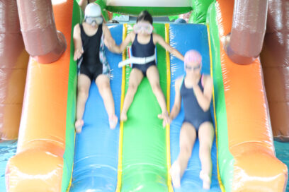 3 enfants descendent d'une structure gonflable à la piscine du Pays de l'Ourcq. - Agrandir l'image, fenêtre modale