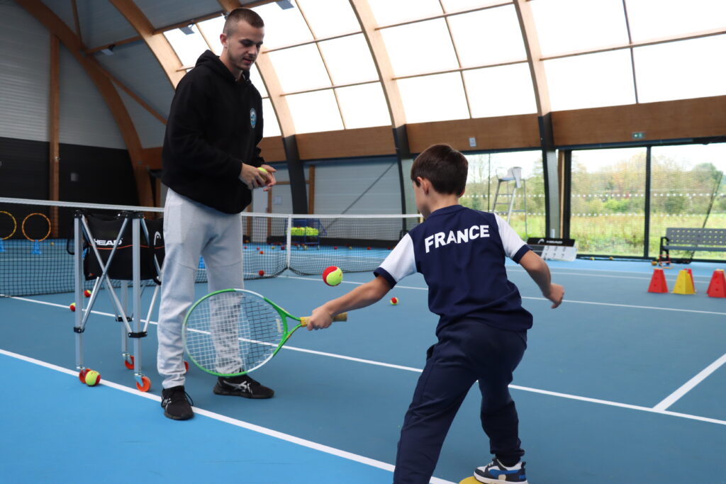 Initiation au tennis avec un enfant et son entraineur au complexe sportif Guy MICHAUX à Ocquerre. - Agrandir l'image, fenêtre modale