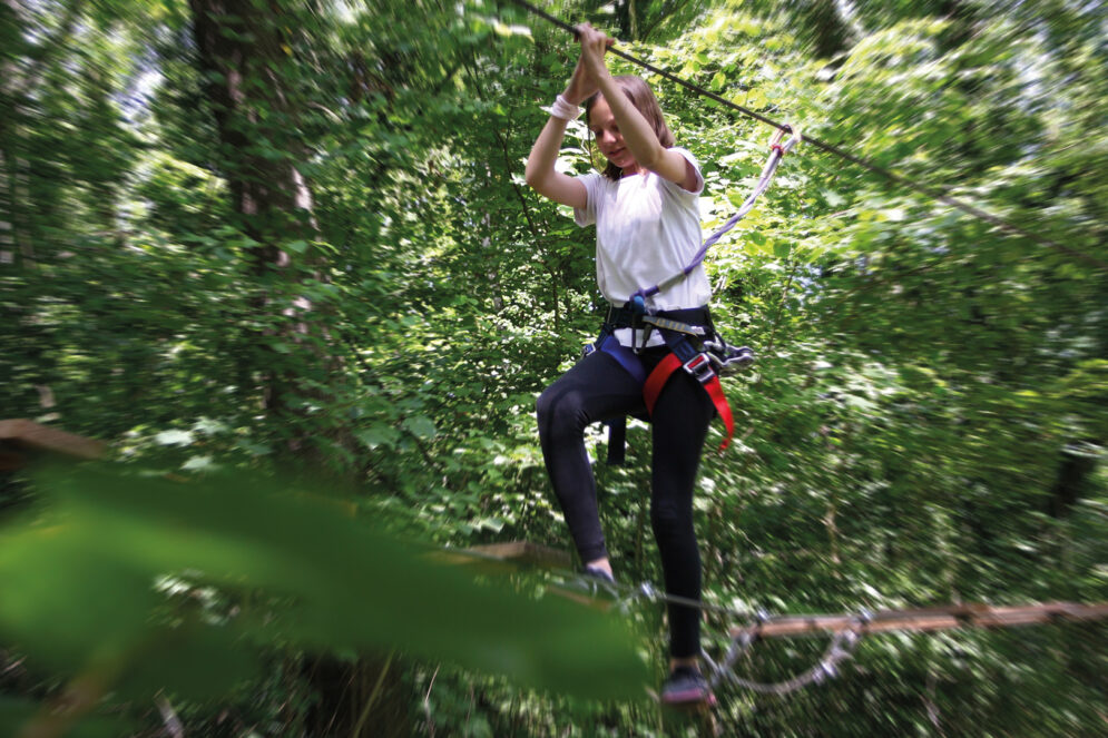 Jeune fille en train de faire de l’accrobranche aux Vac'enSports !